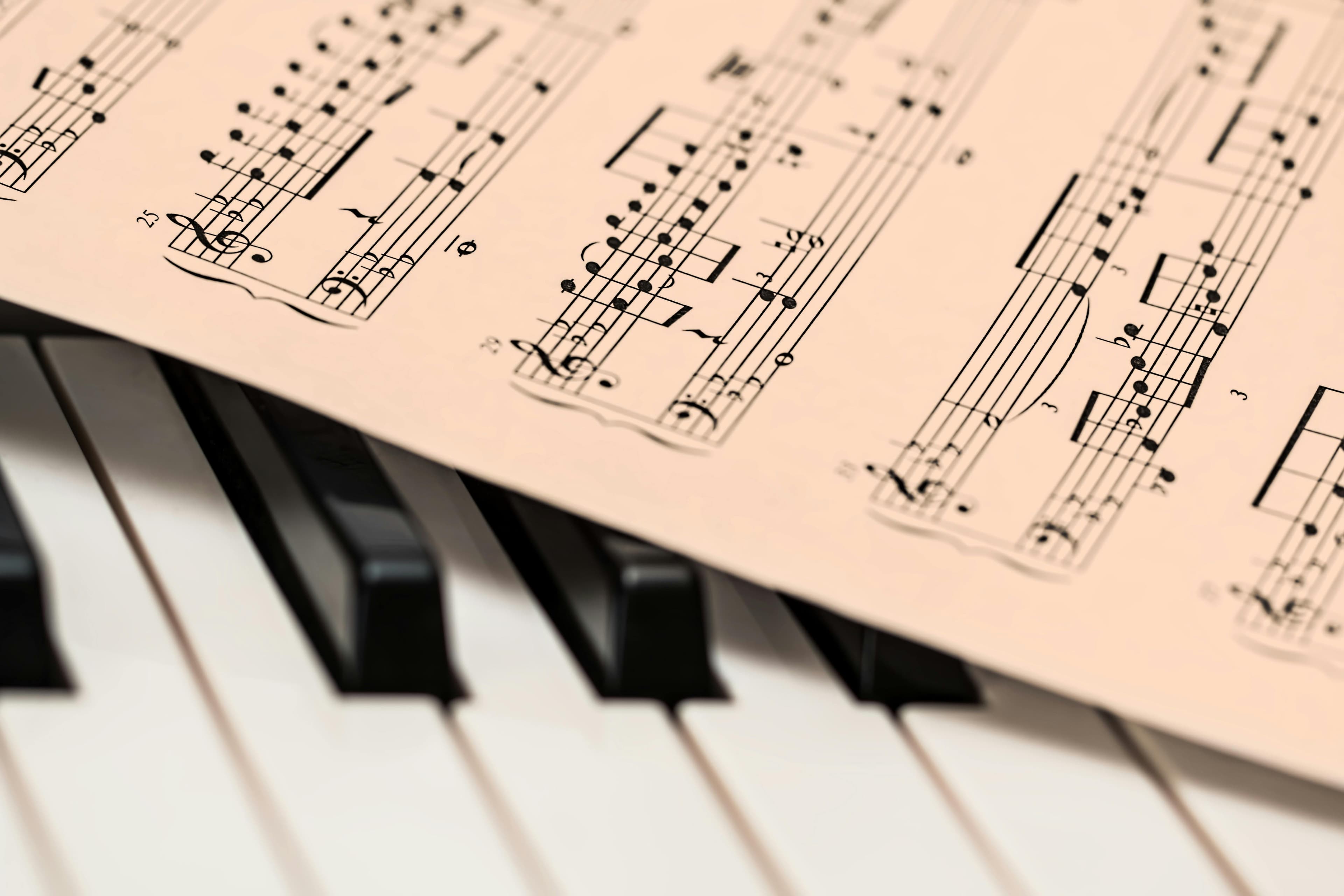Sheet music resting across piano keys